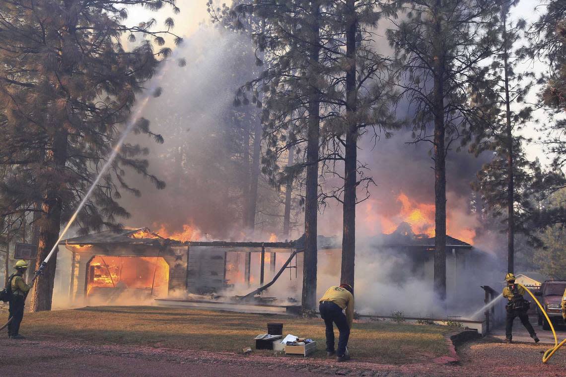 Cal Fire firefighters try to stop flames from the Mill Fire from spreading on a property in the Lake Shastina subdivision northwest of Weed, Calif., on Friday, Sept. 2, 2022.