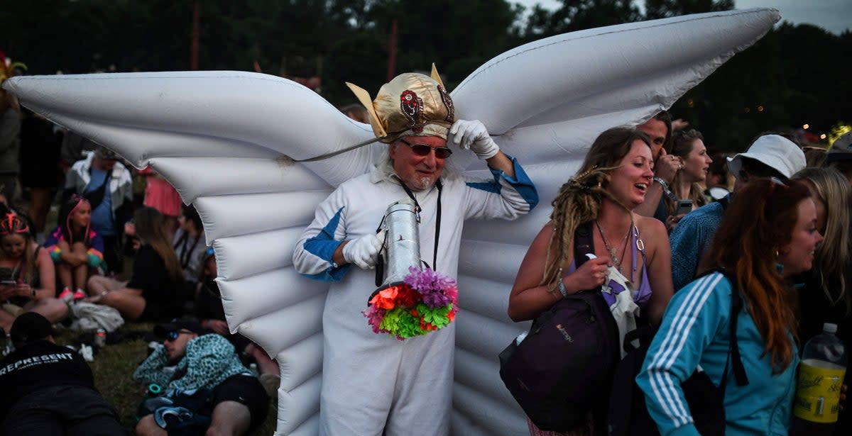 A festival goer wearing inflatable wings walks among the crowd during the first day of the Glastonbury festival (AFP via Getty Images)