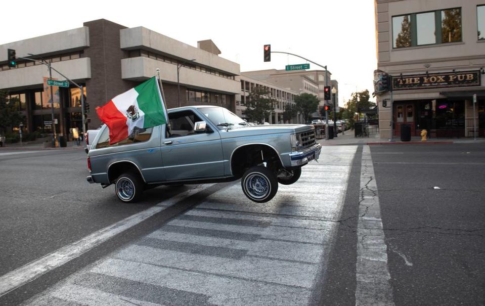 Miembros de clubes automovilísticos recorren I Street durante el recorrido del Día de la Independencia en Modesto, California, el viernes 9 de septiembre de 2022.