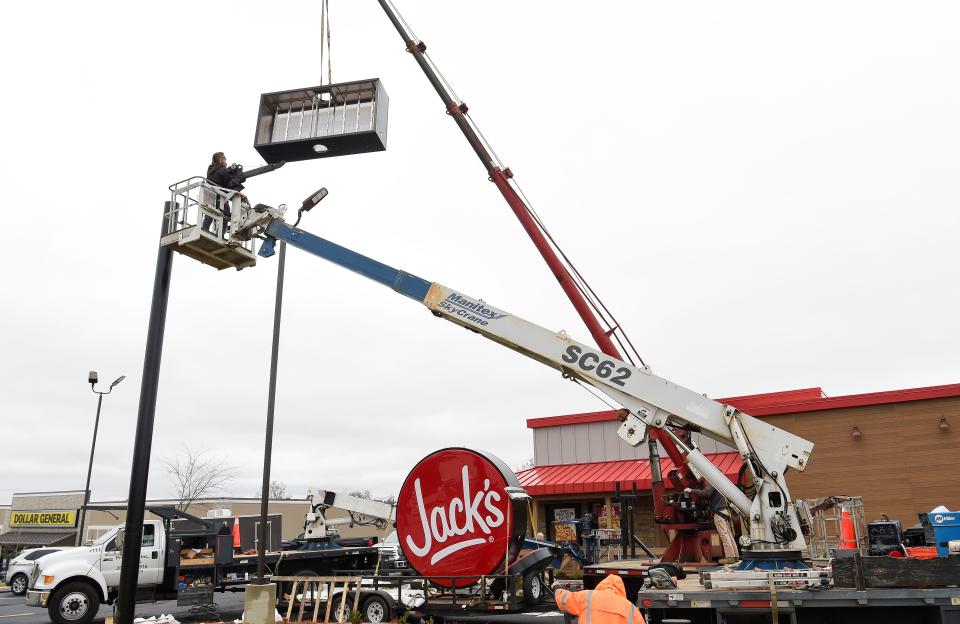 A work crew raises the sign for the new Jack's restaurant on University Blvd. in Alberta Friday, Feb. 25, 2022.