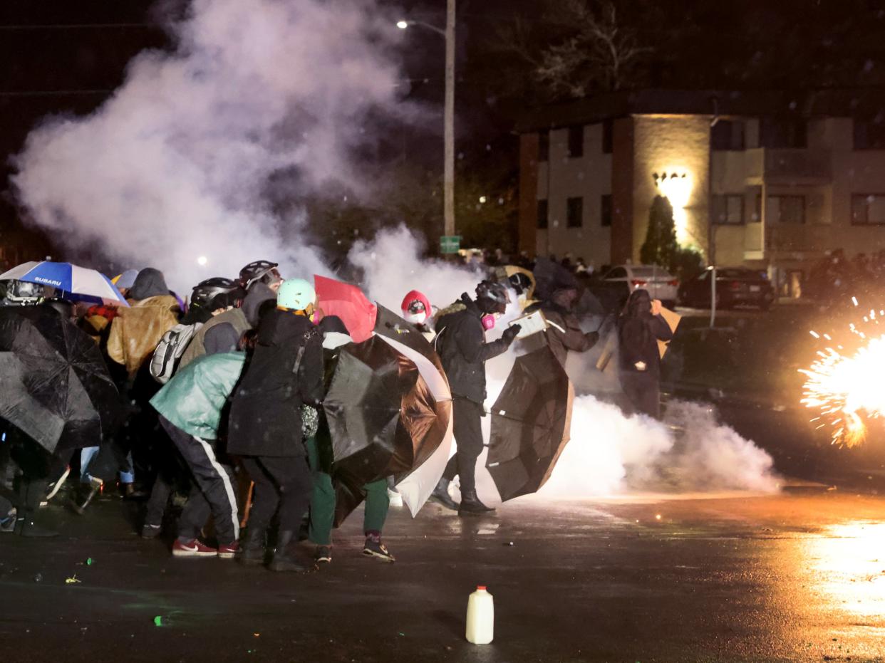 <p>Demonstrators protesting the shooting death of Daunte Wright face off with police near the Brooklyn Center police station on 13 April, 2021 in Brooklyn Center, Minnesota</p> (Getty Images)