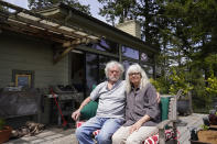 Gordon Bennett and his wife Kate Carolan sit outside their home, Friday, April 30, 2021, in Inverness, Calif. The couple, who were victims of Bernard Madoff and forced to sell their home, now rent it back from someone they know who purchased it. More than 12 years after Madoff confessed to running the biggest financial fraud in Wall Street history, a team of lawyers is still at work on a sprawling effort to recover money for the thousands of victims of his scam. (AP Photo/Eric Risberg)