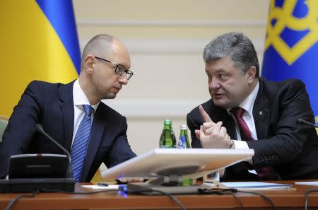 Ukrainian President Petro Poroshenko (R) talks with Prime Minister Arseny Yatseniuk during a government meeting in Kiev, September 10, 2014. REUTERS/Andrew Kravchenko/Pool