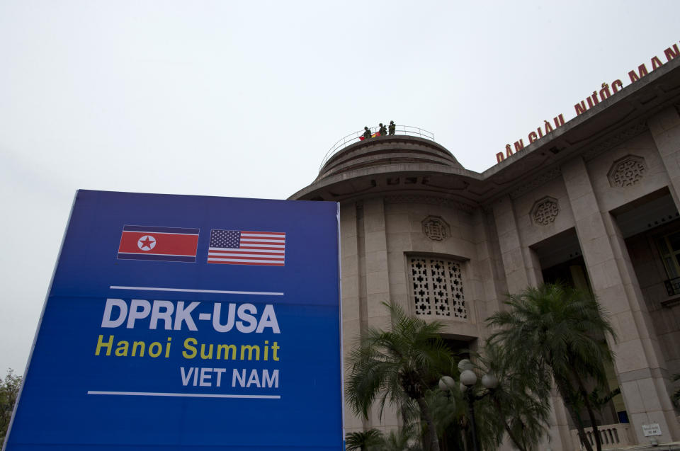 Vietnamese soldiers watch from a top of a building neighboring Government Guesthouse and the Metropole hotel next to a poster featuring upcoming summit between the U.S. and North Korea in Hanoi, Vietnam, Sunday, Feb. 24, 2019. The second summit between U.S President Donald Trump and North Korean leader Kim Jong Un will take place in Hanoi on Feb. 27 and 28. (AP Photo/Gemunu Amarasinghe)