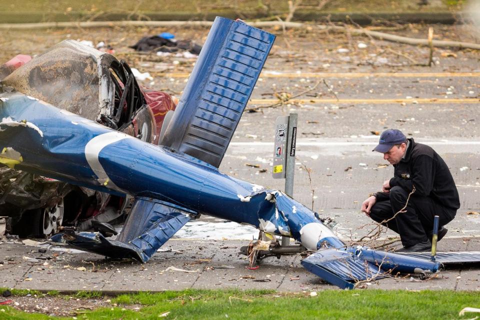 Un investigador revisa los restos de un helicóptero de noticias que se estrelló en una calle el martes 18 de marzo de 2014 cerca de la Aguja Espacial de Seattle, Washington. (Foto AP/seattlepi.com, Jordan Stead)