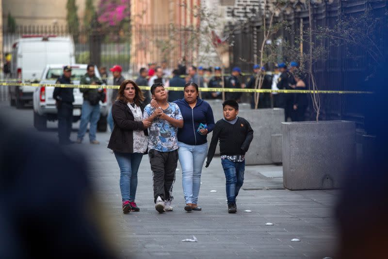 People react at a crime scene where four people were killed and two injured in a shooting near Mexico's National Palace, the presidential residence in the capital's historic downtown, officials said, in Mexico City