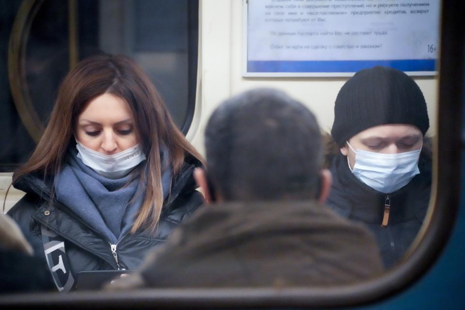 People wearing face masks to help protect against the spread of the coronavirus ride a a subway car in an underground in St. Petersburg, Russia, Friday, Jan. 21, 2022. Daily new coronavirus infections in Russia have reached an all-time high and authorities are blaming the highly contagious omicron variant, which they expect to soon dominate the country's outbreak. Record numbers of new cases were reported in Moscow and in St. Petersburg, where health officials on Friday limited elective outpatient care.(AP Photo/Dmitri Lovetsky)