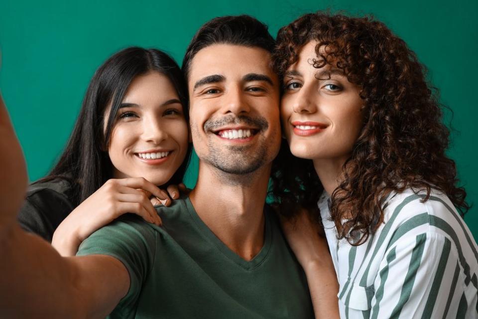 throuple taking a selfie