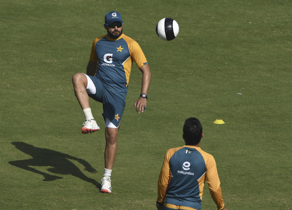 Pakistan's Azhar Ali, center, kicks a soccer ball during a practice session at National Stadium in Karachi, Pakistan, Monday, Jan. 25, 2021. Pakistan will play the first test match against South Africa on Jan. 26. (AP Photo/Fareed Khan)