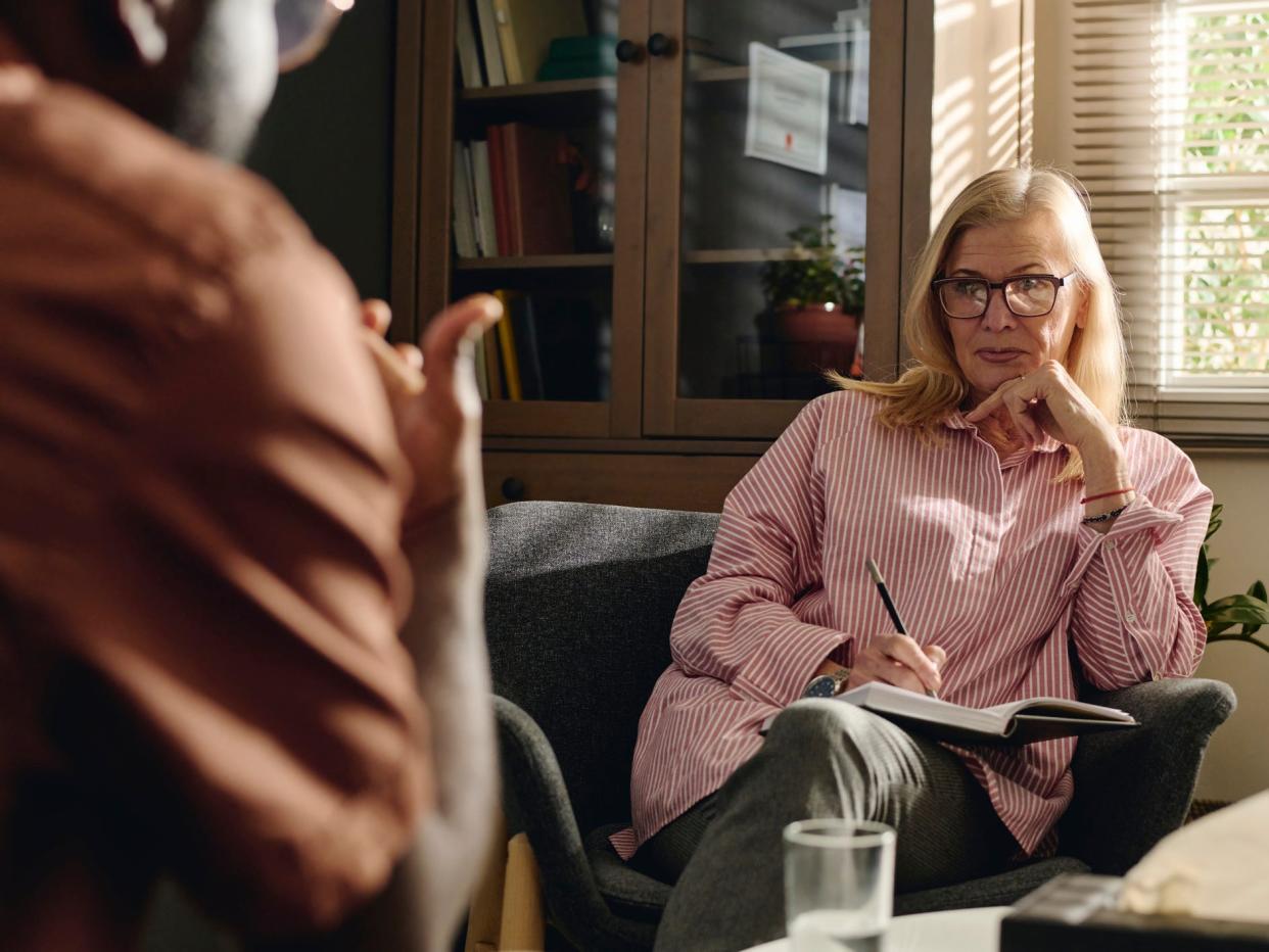 A skeptical looking therapist talking to a client