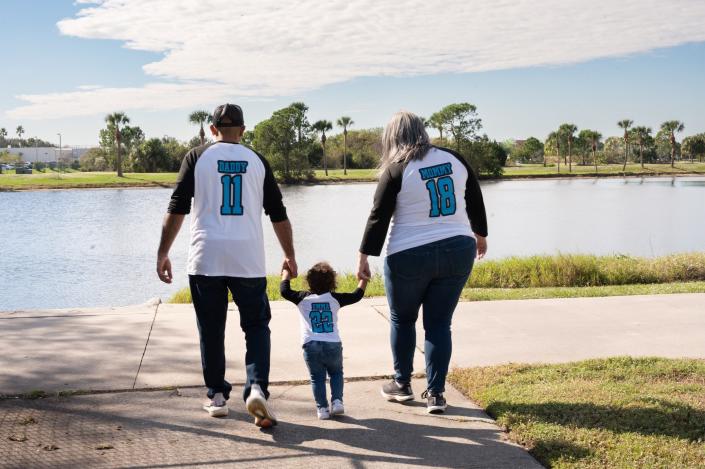 Sanjay and Stacey Patel, who left Brevard County in May 2023, walk with their daughter, Emma, after adopting her in November 2022.