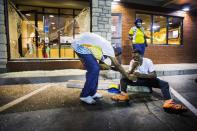 <p>Protesters react to the effects of tear gas which was fired at demonstrators reacting to the shooting of Michael Brown in Ferguson, Missouri August 17, 2014. Shots were fired and police shouted through bullhorns for protesters to disperse, witnesses said, as chaos erupted Sunday night in Ferguson, Missouri, which has been racked by protests since the unarmed black teenager was shot by police on August 9. (Lucas Jackson/Reuters) </p>