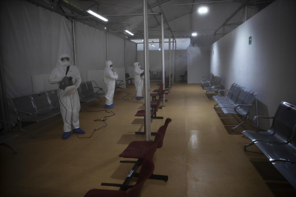 Sanitation technicians disinfect a tent used to test patients for COVID-19 at the Ajusco Medio General Hospital in Mexico City, Thursday, Nov. 19, 2020. (AP Photo/Marco Ugarte)