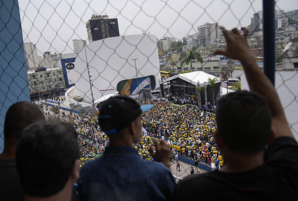 Supporters of Brazilian President Jair Bolsonaro watch his campaign rally for reelection in Duque de Caxias, Rio de Janeiro state, Brazil, Friday, Oct. 14, 2022. The presidential run-off election is Oct. 30. (AP Photo/Silvia Izquierdo)