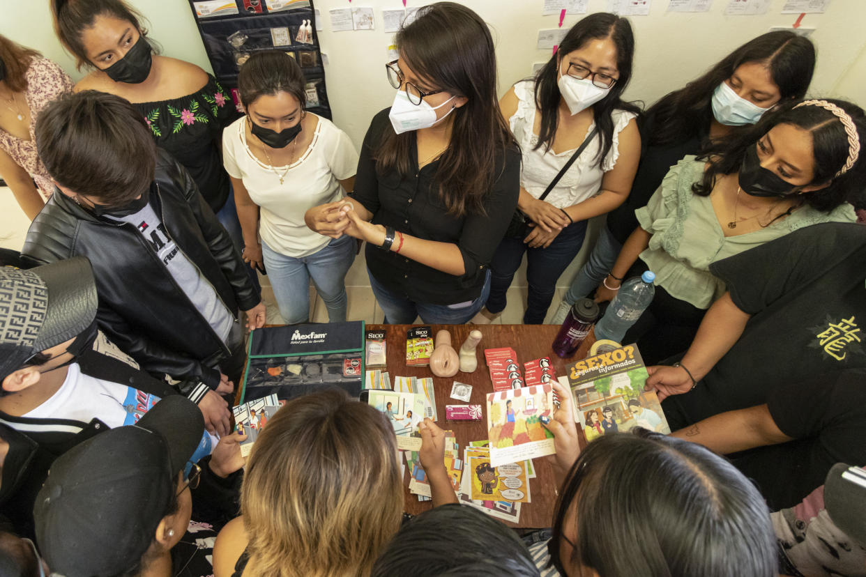 Sinai Toledo of MexFam, center, leads a class during a sex education fair in Oaxaca, Mexico, Friday, Oct. 14, 2022. Mexfam, a national organization promoting sexual and reproductive rights, launched an initiative in 2020 to build a network of doctors that women from Oaxaca’s central valleys could visit if they were considering ending a pregnancy. (AP Photo/Maria Alferez)