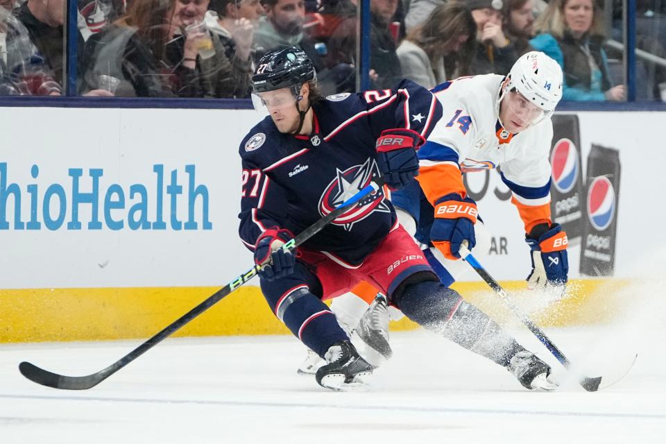 Mar 24, 2023; Columbus, Ohio, USA;  Columbus Blue Jackets defenseman Adam Boqvist (27) skates around New York Islanders center Bo Horvat (14) during the second period of the NHL hockey game at Nationwide Arena. Mandatory Credit: Adam Cairns-The Columbus Dispatch