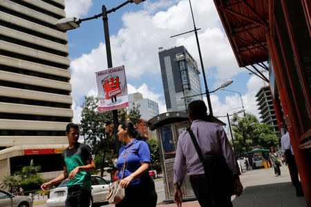 Pedestrians walk past banners against the National Constituent Assembly in a street of Caracas, Venezuela, July 24, 2017. The banner reads "No to fraud". REUTERS/Andres Martinez Casares