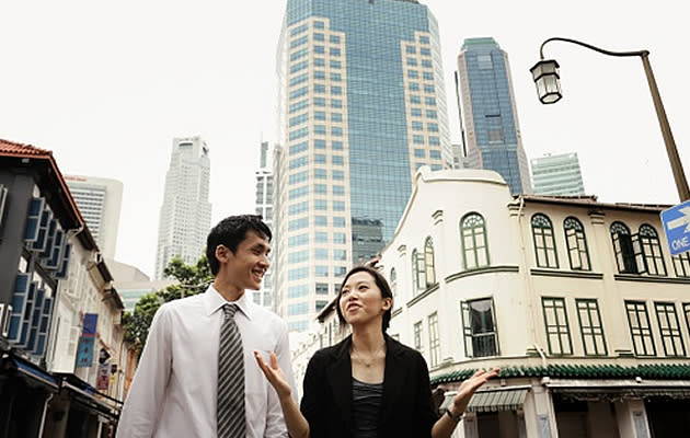 Two colleagues walking and chatting in the city. (Getty Images photo)