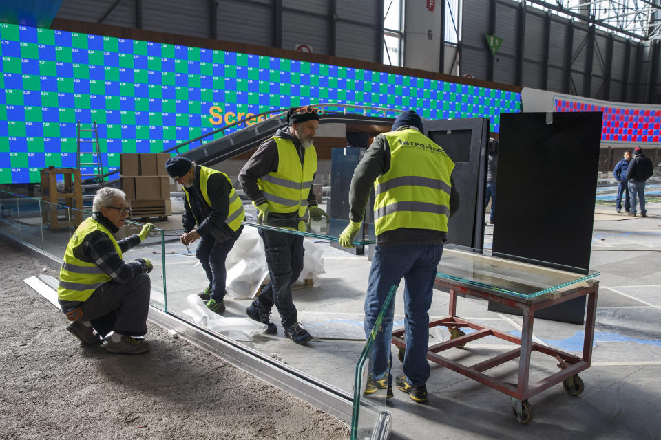 Workers dismantle a booth after that the 90th Geneva International Motor Show (GIMS) is cancelled by Swiss authorities, at the Palexpo in Geneva, Switzerland, Friday, Feb. 28, 2020. The 90th edition of the International Motor Show, scheduled to begin on March 5th, is cancelled due to the advancement of the (Covid-19) coronavirus in Switzerland. The Swiss confederation announced today that all events involving more than 1,000 people would be banned until 15 March. (KEYSTONE/Salvatore di Nolfi)