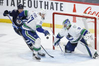 Vancouver Canucks' Tyler Myers (57) blocks a shot in front of Canucks goaltender Spencer Martin (30) who defends against Winnipeg Jets' Kristian Vesalainen (93) during second-period NHL hockey game action in Winnipeg, Manitoba, Thursday, Jan. 27, 2022. (John Woods/The Canadian Press via AP)