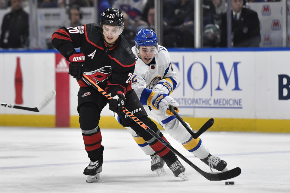 Carolina Hurricanes center Sebastian Aho (20) skates with the puck while pressured by Buffalo Sabres right wing Jack Quinn (22) during the first period of an NHL hockey game in Buffalo, N.Y., Wednesday, Feb. 1, 2023. (AP Photo/Adrian Kraus)