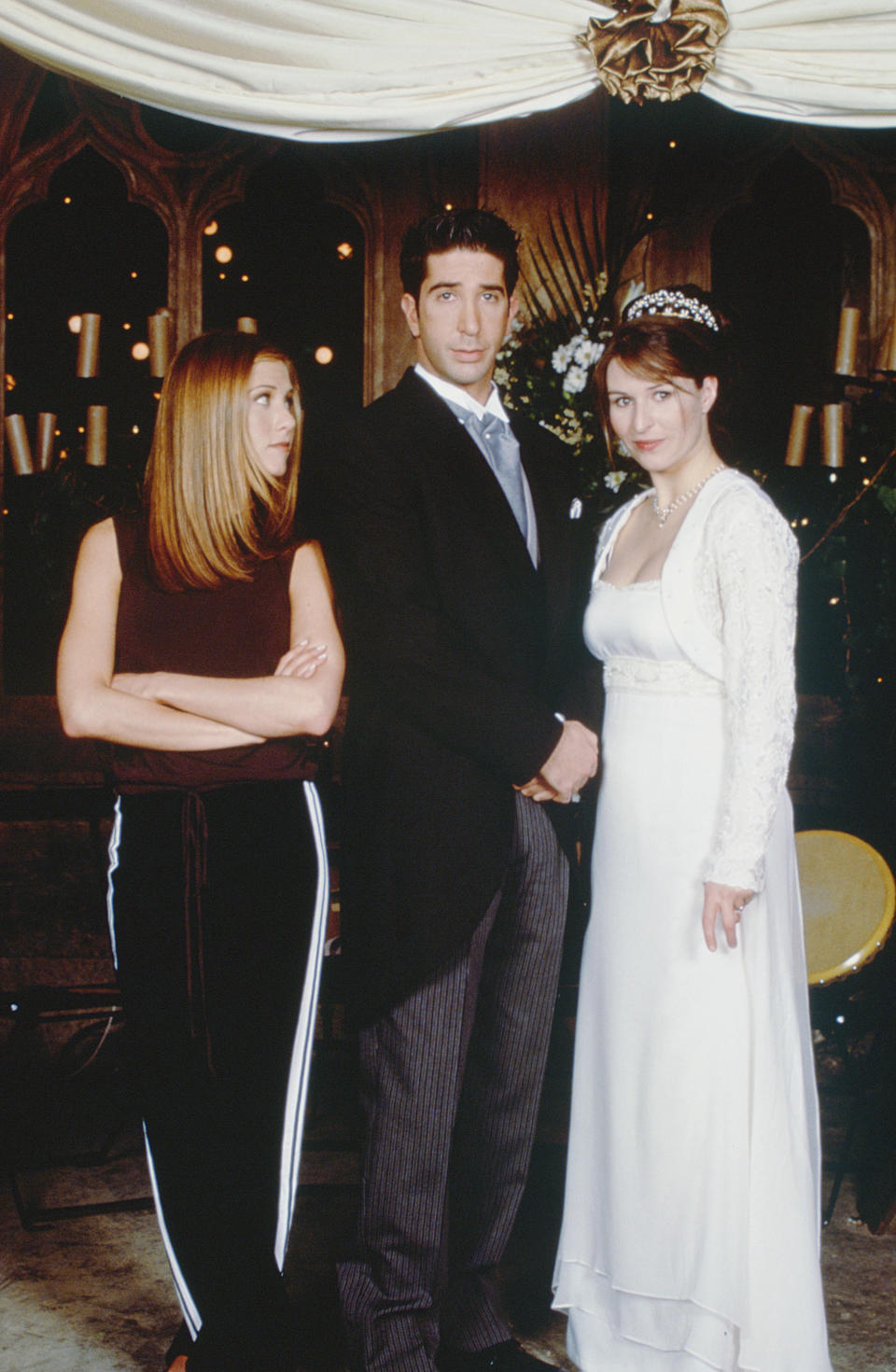 Rachel standing with Ross and Emily at their wedding