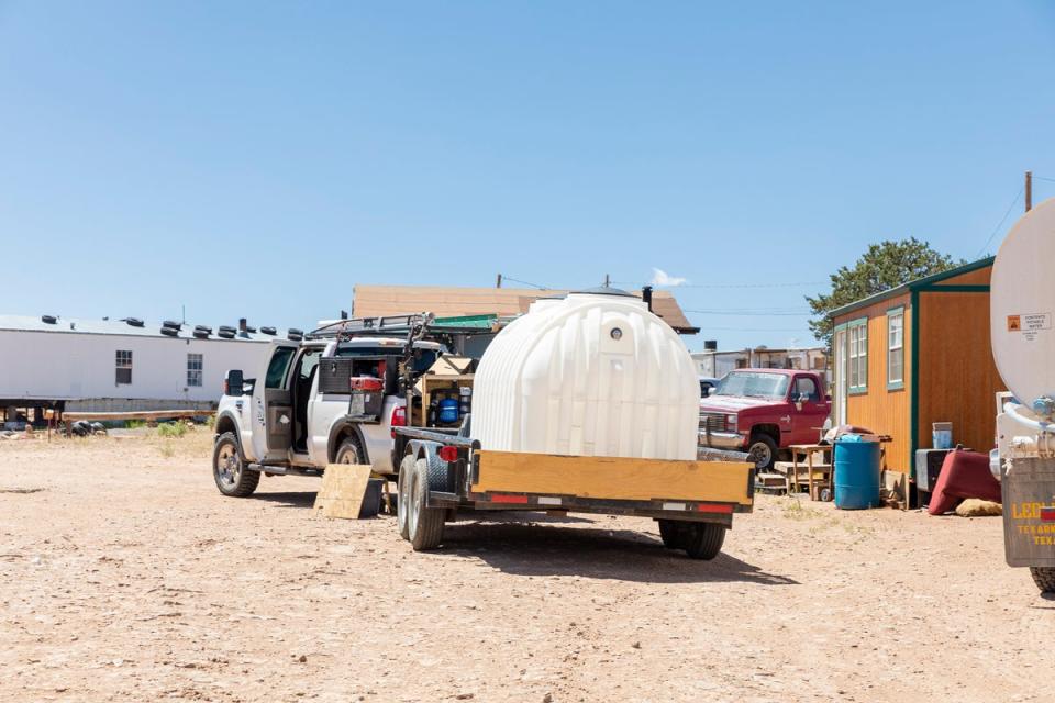 The Navajo Water Project team work on installing a 1,200-gallon tank at a family’s home outside of Prewitt, New Mexico (Gabriella Marks for The Independent)