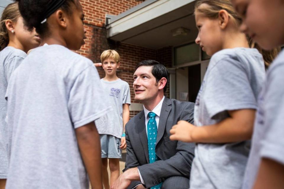 Dr. Gregory Monroe, Superintendent of Catholic school for the Diocese of Charlotte, squats down to speak with children attending a summer camp at St. Matthew Catholic School on Friday, July 22, 2022 in Charlotte, NC.