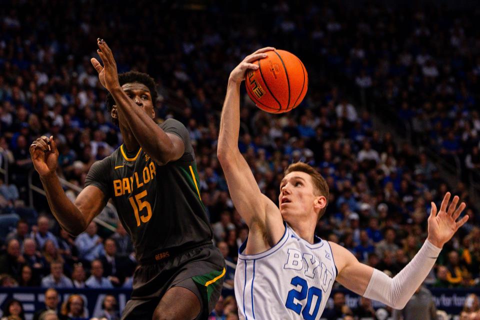 Brigham Young Cougars guard Spencer Johnson (20) fakes to shoot the ball with Baylor Bears forward Josh Ojianwuna (15) jumping up to block the shot during a men’s college basketball game between Brigham Young University and Baylor University at the Marriott Center in Provo on Tuesday, Feb. 20, 2024. | Megan Nielsen, Deseret News