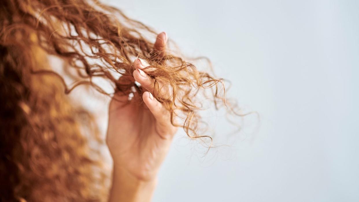 woman running fingers through curly hair