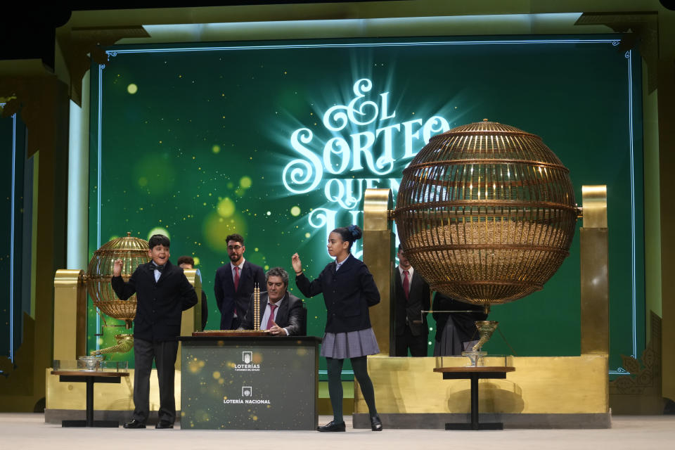 Children from Madrid's San Ildefonso school sing out the numbers from one of the main prizes from awarded lottery balls at Madrid's Teatro Real opera house during Spain's bumper Christmas lottery draw known as El Gordo, or The Fat One, in Madrid, Spain, Friday, Dec. 22, 2023. The lottery will shell out 400,000 euros ($440,000) to holders of 20-euro tickets bearing the top-prize number. The immensely popular lottery will distribute a total of 2.6 billion euros in prizes this year, much of it in small prizes. Street and bar celebrations normally break out with winners uncorking bottles of sparkling wine and singing and dancing. (AP Photo/Paul White)