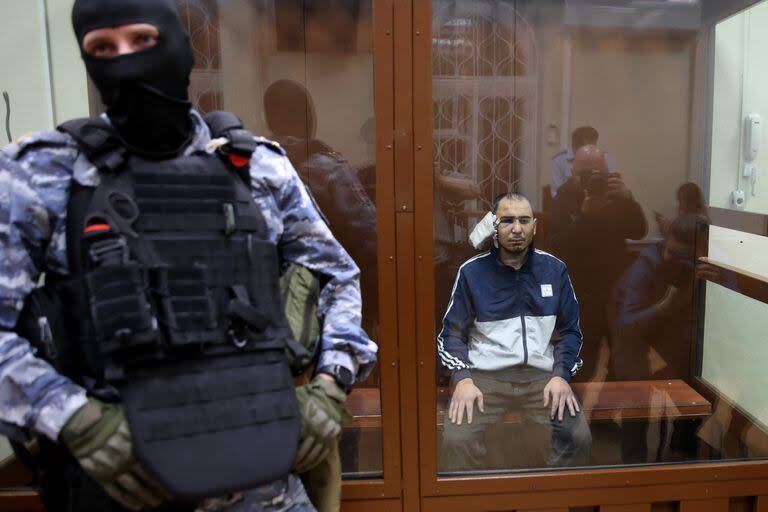 Un hombre sospechoso de participar en el ataque a una sala de conciertos que mató a 137 personas, el ataque más mortífero en Europa reivindicado por el grupo yihadista Estado Islámico, se sienta en la jaula del acusado mientras espera su audiencia de prisión preventiva en en el Tribunal de Distrito de Basmanny en Moscú el 24 de marzo de 2024.