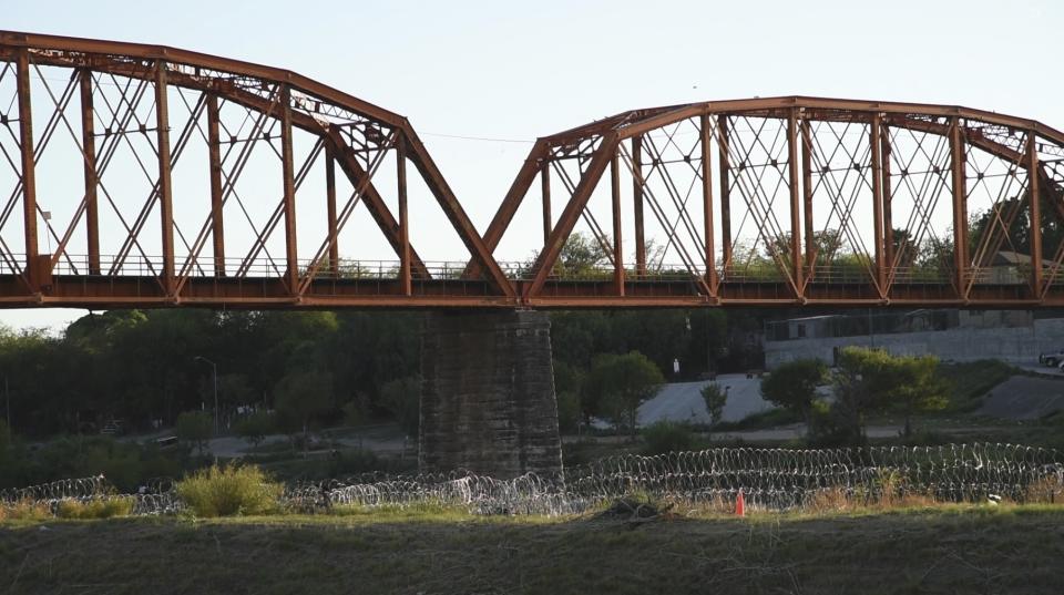 Razor wire coils underneath a railroad bridge in Eagle Pass, Texas on Sept. 9, 2023, to deter the thousands of migrants using the border city as a popular crossing point into the U.S. The increase crossings prompted Customs and Border Protection to temporarily shut down the railroad gateway in the city and in El Paso, Texas on Dec. 18, 2023, to reallocate officers to help Border Patrol agents take migrants into custody. (AP Photo/Valerie Gonzalez)