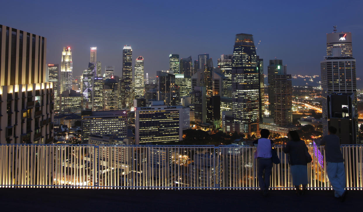 People look at the skyline of the central business district from the Skybridge of The Pinnacles at Duxton public housing estate in Singapore April 25, 2013. Banks in Singapore are urgently scrutinising their account holders as an imminent deadline on stricter tax evasion measures forces them to decide whether to send some of their wealthiest clients packing. The Southeast Asian city-state has grown into the world's fourth-biggest offshore financial centre but, with U.S. and European regulators on the hunt for tax cheats, the government is clamping down to forestall the kind of onslaught from foreign authorities that is now hitting Switzerland's banks. Before July 1, all financial institutions in Singapore must identify accounts they strongly suspect hold proceeds of fraudulent or wilful tax evasion and, where necessary, close them. After that, handling the proceeds of tax crimes will be a criminal offence under changes to the city-state's anti-money laundering law. Picture taken April 25, 2013. REUTERS/Edgar Su (SINGAPORE - Tags: CITYSCAPE BUSINESS)