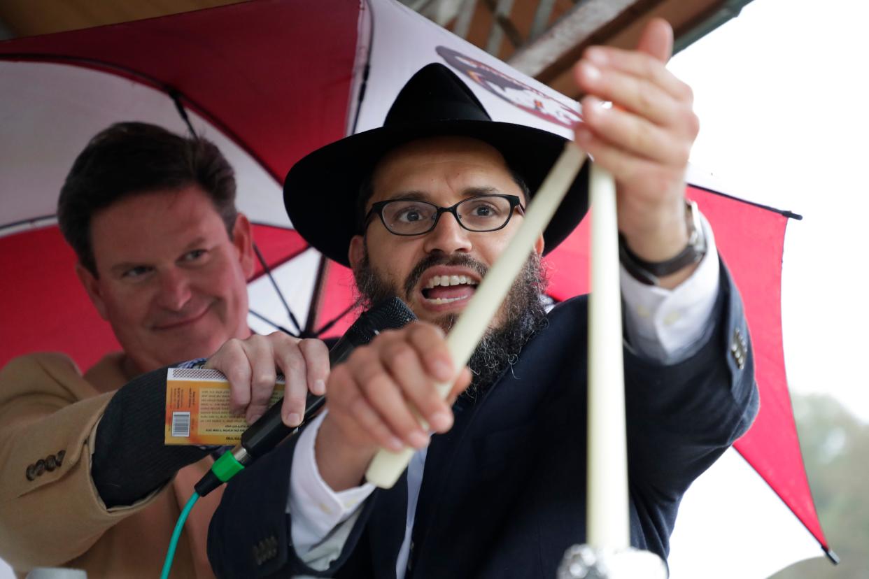 Rabbi Schnuer Zalman Oirechman lights the first candle on the menorah, marking the first night of Hanukkah on Chabad of Tallahassee's 9-foot menorah at Lake Ella Sunday, Dec. 22, 2019.