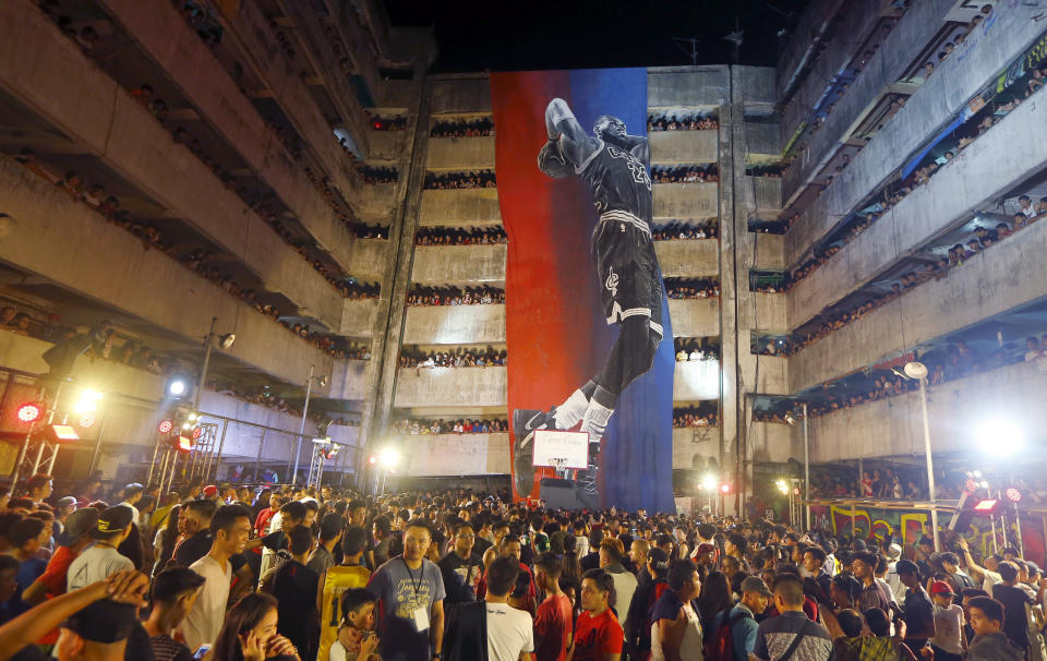 FILE - Filipino fans react as a giant mural of three-time NBA champion LeBron James of the Cleveland Cavaliers is unveiled at a housing community known as "Tenement" in suburban Taguig city east of Manila, Philippines, Saturday, Sept. 2, 2017. The island nation has basketball courts everywhere, an incredible passion for the NBA and now gets to showcase Manila as the centerpiece of the Basketball World Cup. (AP Photo/Bullit Marquez, FIle)