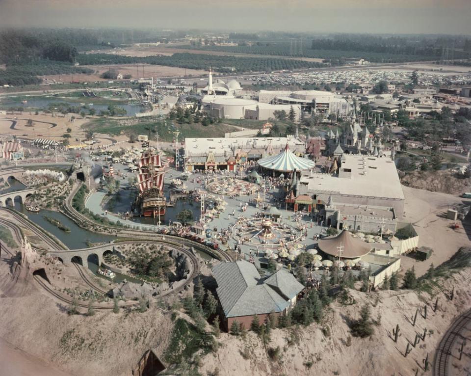 Aerial view of Disneyland, featuring Sleeping Beauty Castle, Fantasyland attractions, and surrounding buildings