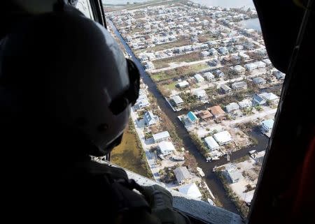 Naval Air Crewman (Helicopter) 3rd Class Austin Rivera, from Fayetteville, N.C., assigned to the Dragon Whales of Helicopter Sea Combat Squadron (HSC) 28, surveys damage caused by Hurricane Irma in the Florida Keys, Florida, U.S. in this handout photo obtained by Reuters September 15, 2017. Mass Communication Specialist 2nd Class Kristopher Ruiz/U.S. Navy/Handout via REUTERS