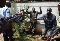 Policemen search a man for weapons as he walked out of Westgate Shopping Centre in Nairobi September 21, 2013. Militant gunmen stormed the shopping mall in Nairobi on Saturday killing at least 39 people, including children, and sending scores fleeing into shops, a cinema and onto the streets in search of safety. Kenyan security forces were still locked in a standoff on Sunday with the al Qaeda-linked militants, who were holding an unknown number of hostages. Picture taken September 21, 2013. REUTERS/Goran Tomasevic (KENYA - Tags: CIVIL UNREST)