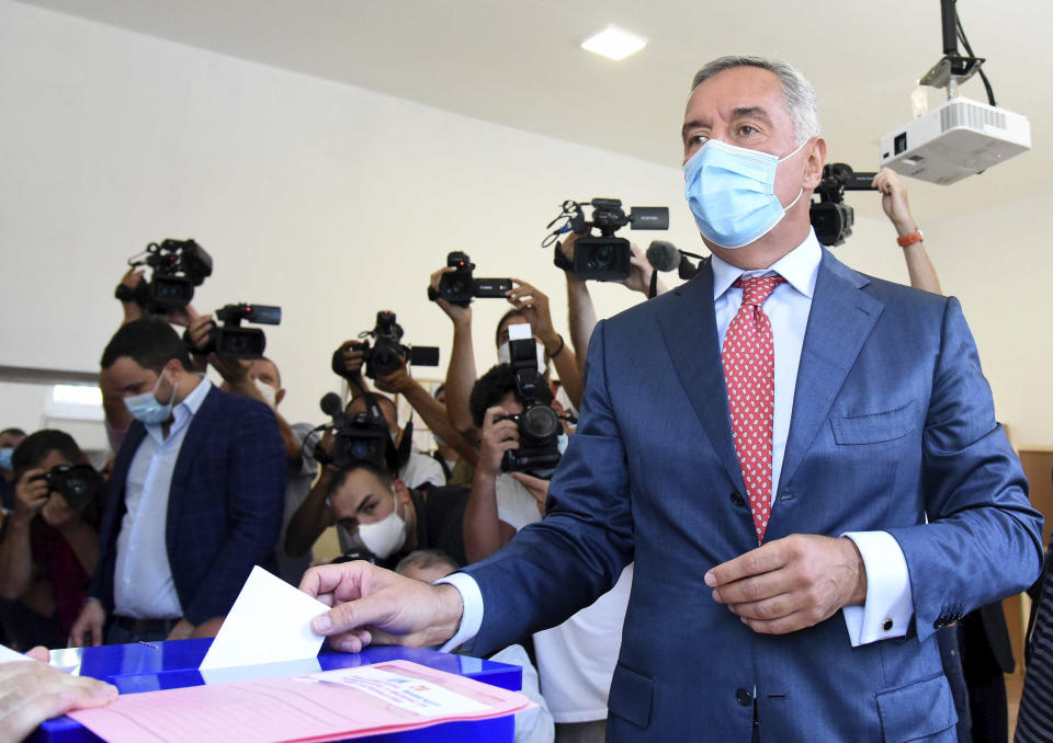 Montenegrin President Milo Djukanovic wearing a mask against the spread of the new coronavirus casts his ballot to vote in parliamentary elections at a polling station in Podgorica, Montenegro, Sunday, Aug. 30, 2020. Voters in Montenegro on Sunday cast ballots in a tense election that is pitting the long-ruling pro-Western party against the opposition seeking closer ties with Serbia and Russia. The parliamentary vote is marked by a dispute over a law on religious rights that is staunchly opposed by the influential Serbian Orthodox Church. (AP Photo/Risto Bozovic)