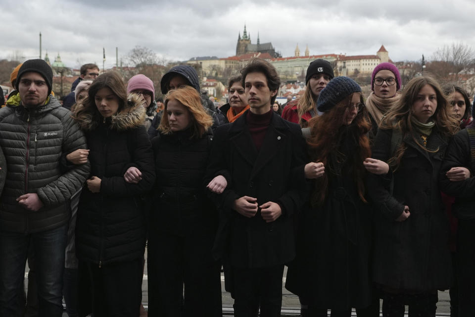 People stand as a human chain to honor victims of mass shooting in front of the building of Philosophical Faculty of Charles University in Prague, Czech Republic, Thursday, Jan. 4, 2024. Thousands of students and other Czechs marched in silence in the Czech capital on Thursday to honor the victims of the country's worst mass killing that left 14 dead on Dec. 21, 2023. (AP Photo/Petr David Josek)