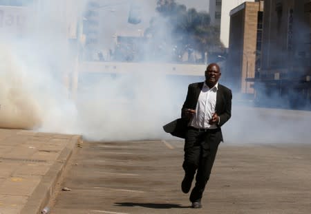 A man flees from teargas during clashes after police banned planned protests over austerity and rising living costs called by the opposition Movement for Democratic Change (MDC) party in Harare