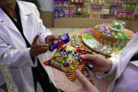 In this Oct. 22, 2018, photo, Kwon Yong Chol, left, the chief engineer at the Songdowon General Foodstuffs Factory, shows samples of products at his facility in Wonsan, North Korea. Though the international spotlight has been on his denuclearization talks with Washington, the North Korean leader has a lot riding domestically on his promises to boost the country's economy and standard of living. His announcement in April that North Korea had sufficiently developed its nuclear weapons and would now focus on building its economy marked a sharp turn in official policy and set the stage for his rapid-fire meetings with the leaders of China, South Korea and the United States. (AP Photo/Dita Alangkara)