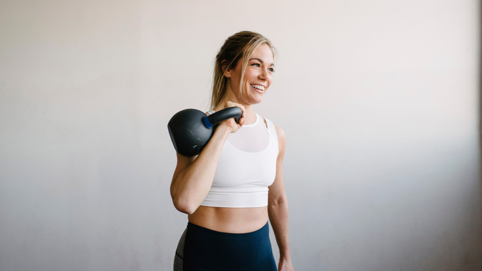 Woman performing a kettlebell front rack carry