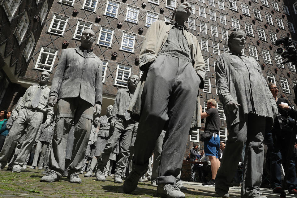 <p>Performance artists covered in clay to look like zombies walk trance-like through the city center during a preliminary performance on July 5, 2017 in Hamburg, Germany. (Friedemann Vogel/Getty Images) </p>