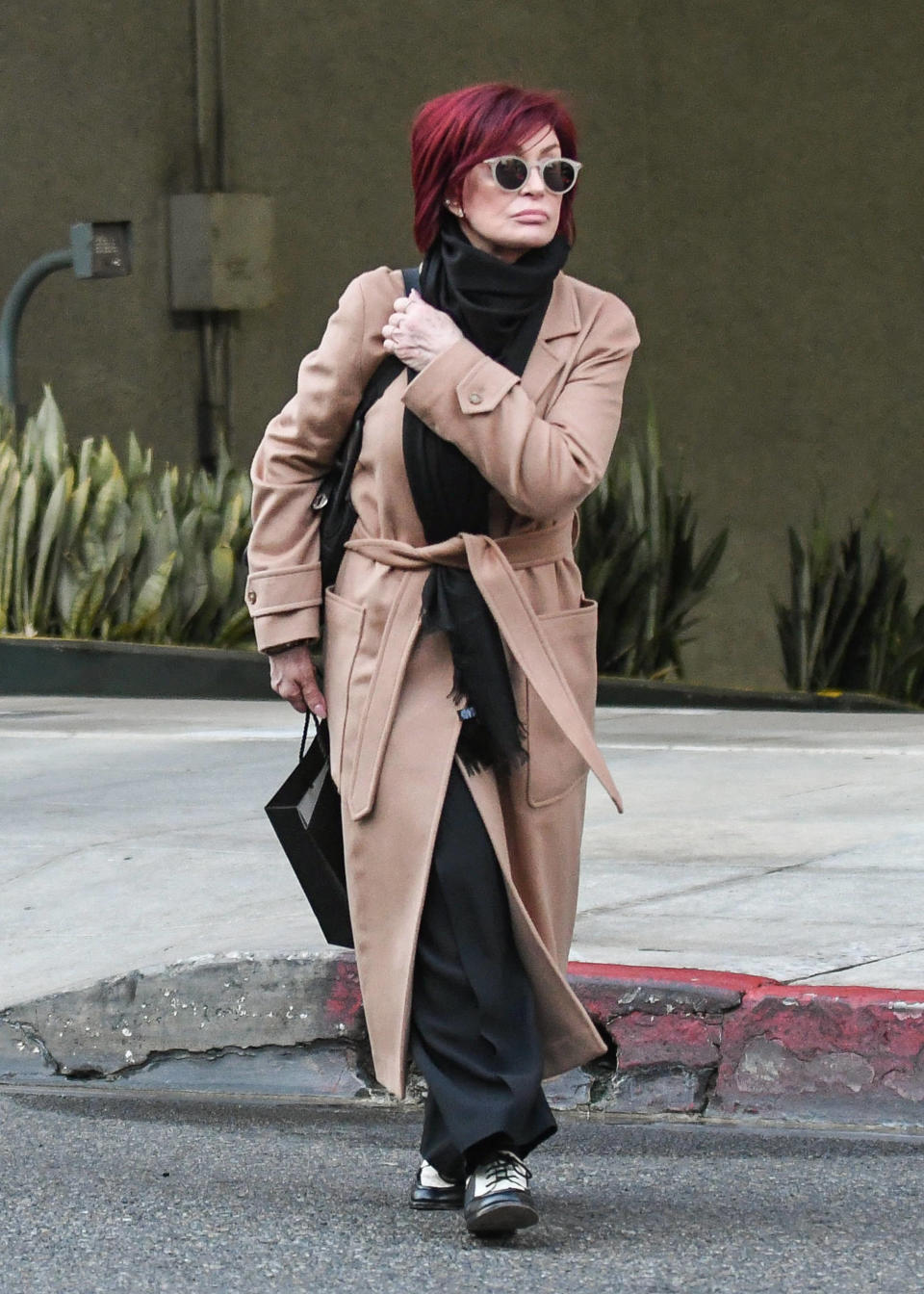 Close-up of Sharon in a coat walking on the street