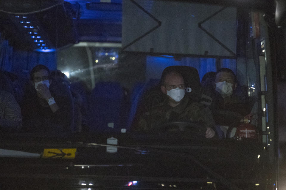 A bus carrying French citizens returning from the virus-hit city of Wuhan arrives in Aix-en-Provence, southern France, Sunday, Feb. 2, 2020. A second French-chartered plane carrying 300 evacuees from China flew to France on Sunday as more foreigners fled China's rapidly developing virus. (AP Photo/Daniel Cole)