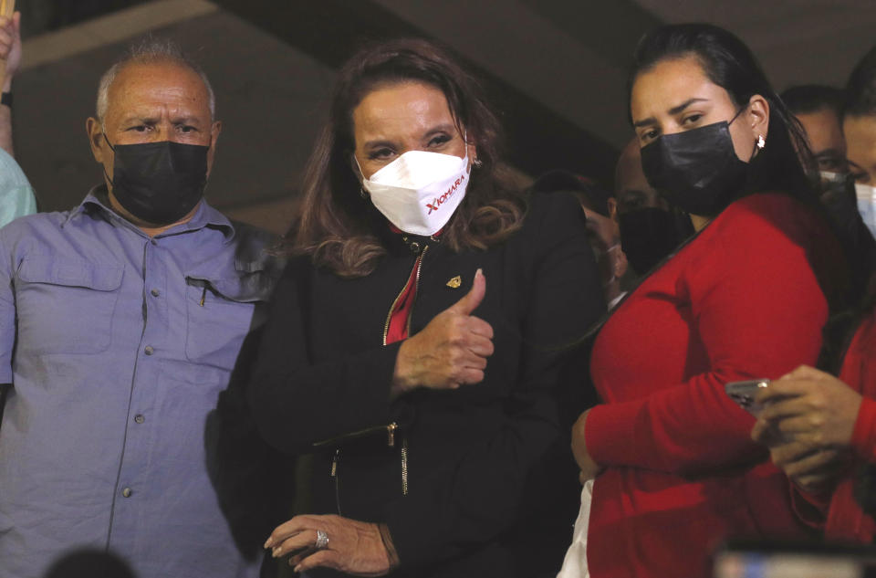 Honduras' President-elect Xiomara Castro, center, greats supporters of her Liberty and Refoundation Party gathered in Tegucigalpa, Honduras, Saturday, Jan. 22, 2022. Castro saw her prospects of a successful administration take a hit even before she's been inaugurated, as a battle for leadership of the newly elected Congress devolved into shouting and shoving among her own allies on Friday. (AP Photo/Elmer Martinez)