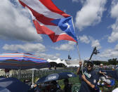Miguel Rosario of Atlantic City, N.J., waves a Puerto Rican Flag while waiting for the start of the National Baseball Hall Of Fame induction ceremony at the Clark Sports Center on Sunday, July 21, 2019, in Cooperstown, N.Y. (AP Photo/Hans Pennink)
