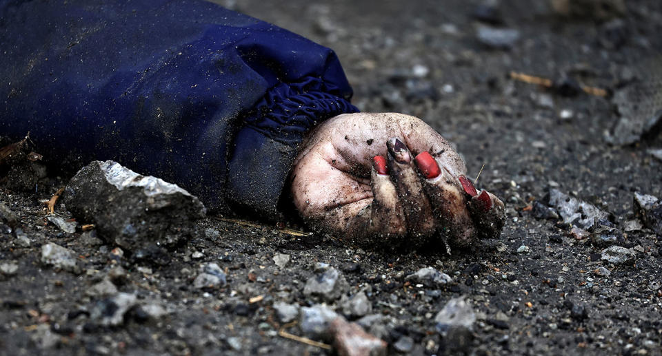 A body of a woman, who according to residents was killed by Russian army soldiers, lies on the street, amid Russia invasion on Ukraine in Bucha.